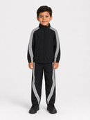 A young boy modeling a black tracksuit with white stripes, consisting of a zip-up jacket and matching pants, on a light gray studio background.