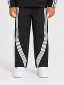 Black track pants with white diagonal stripes down the sides, worn by a model with white sneakers against a light gray background.