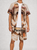 Rebel Minds Paradise tapestry shirt in khaki, casual tee with vibrant print, worn by a model in Stockton, California.