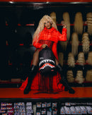 Person in a red outfit with a shark-themed bag in a store setting
