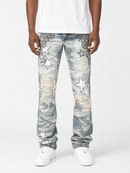 A person wearing light-wash distressed denim jeans with large white star patches, faded blue wash areas, and black ornamental embroidery near the upper thighs, paired with a white t-shirt and white sneakers against a light gray studio background.