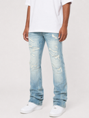 A person wearing light-wash blue distressed jeans with ripped details, paired with a white t-shirt and white sneakers, shown from the waist down against a plain light background.