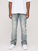 A person wearing light-wash distressed denim jeans with ripped details, paired with a white t-shirt and white sneakers, shown from the waist down against a plain light gray studio background.
