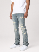 A person wearing light-wash distressed denim jeans with ripped details, paired with a white t-shirt and white sneakers, shown from the waist down on a light gray studio background.