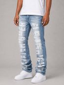 A person wearing light blue distressed denim jeans with large white 'FLEEMIGH' text printed down the front of both legs, styled with a white t-shirt and white sneakers against a neutral gray studio background.