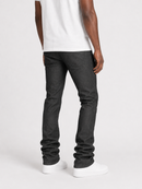 Rear three-quarter view of a person wearing dark charcoal gray slim-fit jeans, a white t-shirt, and white sneakers against a light gray studio background.