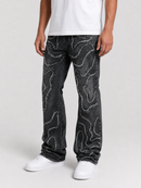 A person wearing dark gray washed jeans with white wavy abstract line patterns, paired with a white t-shirt and white sneakers, shown from the waist down on a light gray studio background.